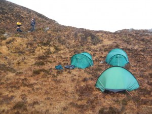 The tents pitched in a bog on the side of a hill