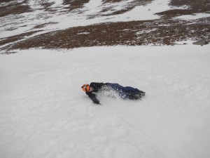 Using the ice axe to spin around and stop during a head first slide